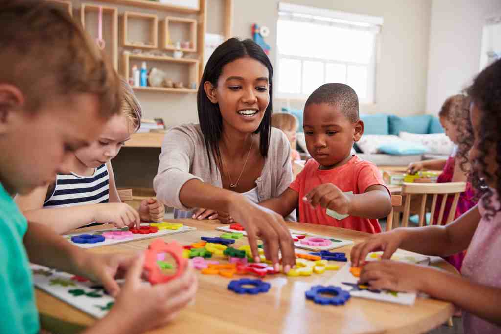 A staff member plays shapes with a child in the setting.